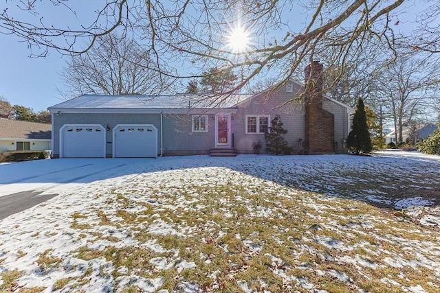 view of front facade with an attached garage and a chimney