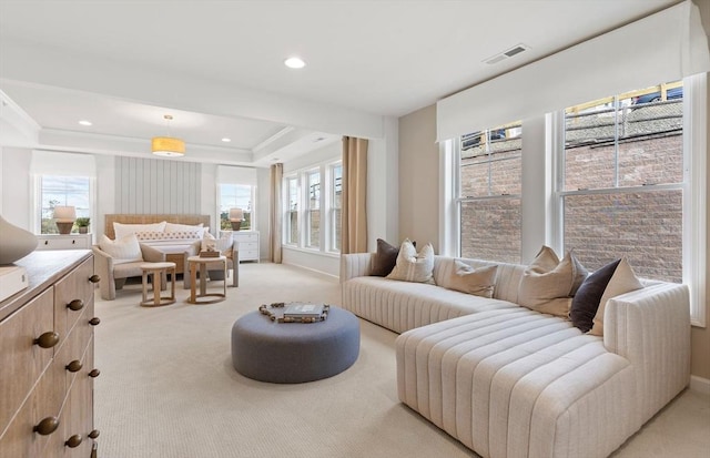 living room with a tray ceiling and light colored carpet