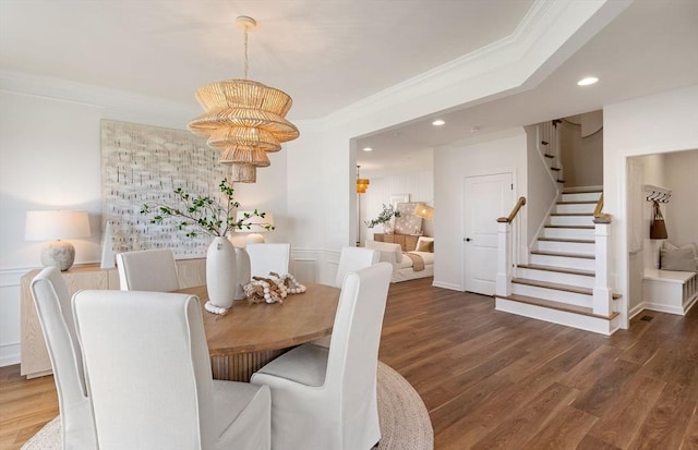 dining room featuring dark hardwood / wood-style floors, an inviting chandelier, and ornamental molding