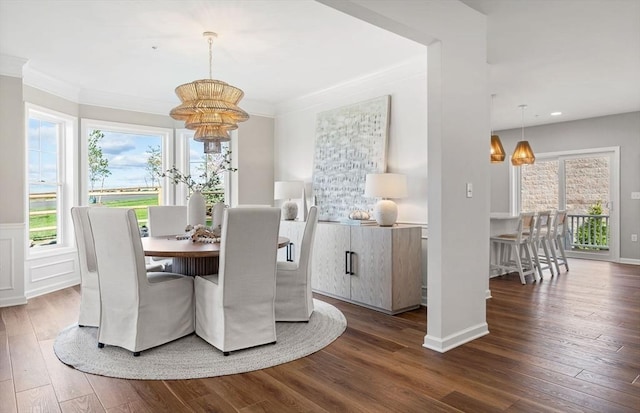 dining space with ornamental molding, dark wood-type flooring, and a notable chandelier