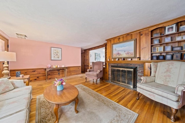 70 Bestick Rd, Braintree, MA 02184 - living area with wood-type flooring, a brick fireplace, and wood walls