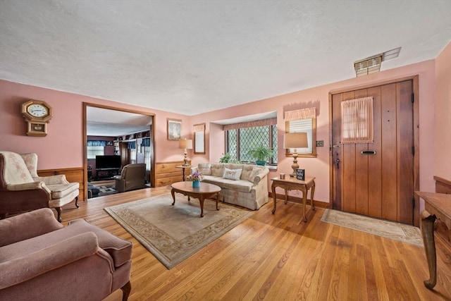70 Bestick Rd, Braintree, MA 02184 - living room with light wood finished floors and a wainscoted wall