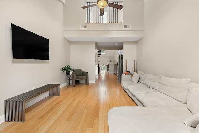 28 Broad St Unit 205, Marlborough, MA 01752 - living room featuring a ceiling fan, light wood finished floors, baseboards, and a towering ceiling