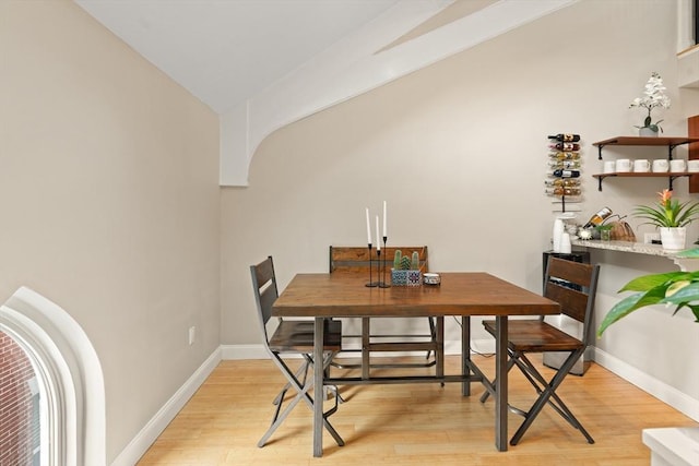 28 Broad St Unit 205, Marlborough, MA 01752 - dining space with lofted ceiling, light wood-type flooring, baseboards, and arched walkways
