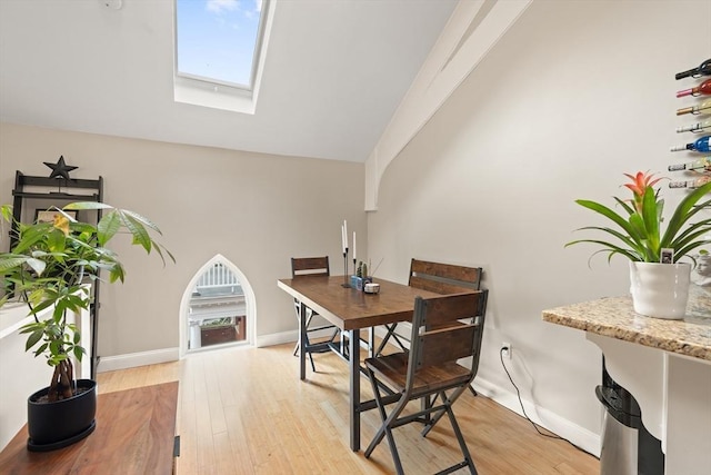 28 Broad St Unit 205, Marlborough, MA 01752 - dining area with light wood finished floors, a skylight, baseboards, and high vaulted ceiling