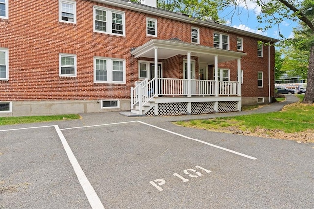 74 Boylston St Unit 2, Newton, MA 02467 - view of property featuring brick siding, uncovered parking, and covered porch