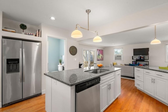 kitchen featuring stainless steel appliances, white cabinets, a sink, and light wood-style flooring