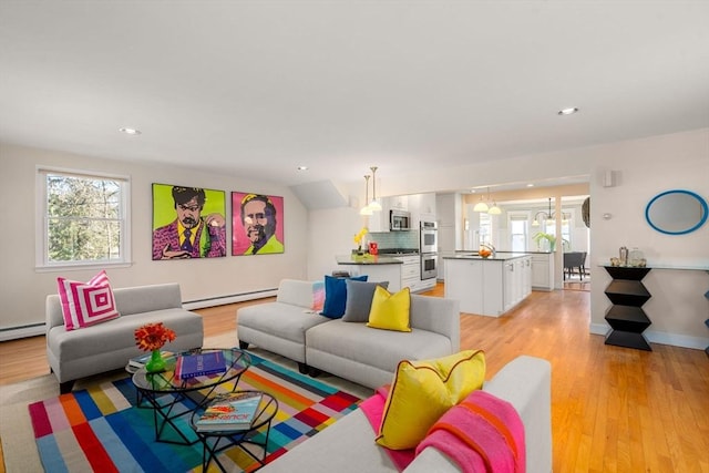 living room featuring lofted ceiling, a baseboard radiator, recessed lighting, baseboards, and light wood-type flooring