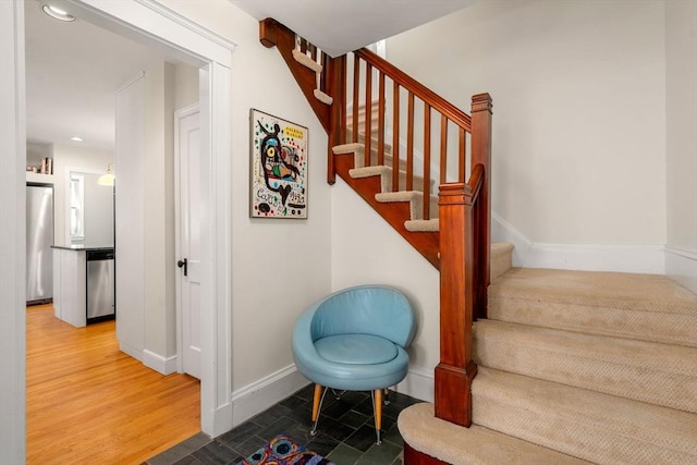 staircase with baseboards and wood finished floors