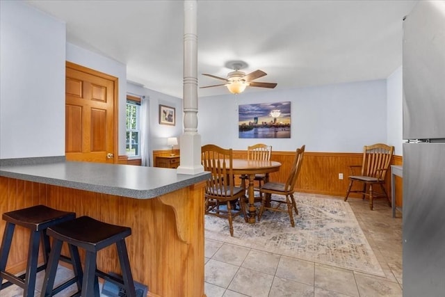 115 Winter St, Whitman, MA 02382 - dining space with ceiling fan, wainscoting, light tile patterned flooring, ornate columns, and wood walls