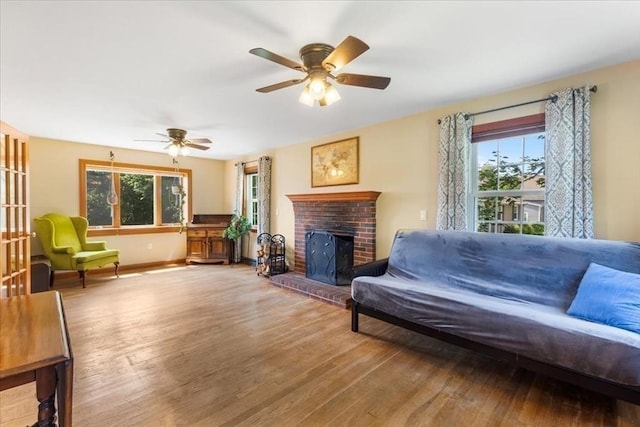 115 Winter St, Whitman, MA 02382 - living area featuring healthy amount of natural light, ceiling fan, wood finished floors, and a brick fireplace