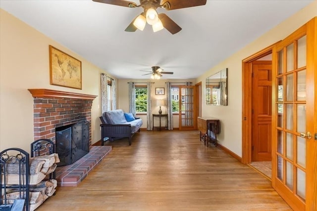 115 Winter St, Whitman, MA 02382 - living room featuring light wood-style floors, a ceiling fan, a fireplace, and french doors