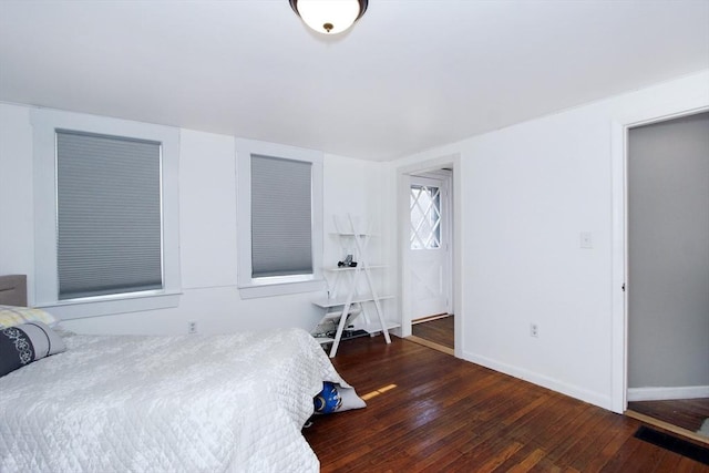 bedroom with dark hardwood / wood-style floors