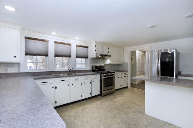 kitchen featuring white cabinetry, stainless steel appliances, sink, and backsplash