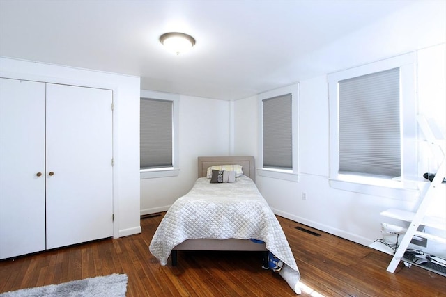 bedroom featuring dark wood-type flooring and a closet