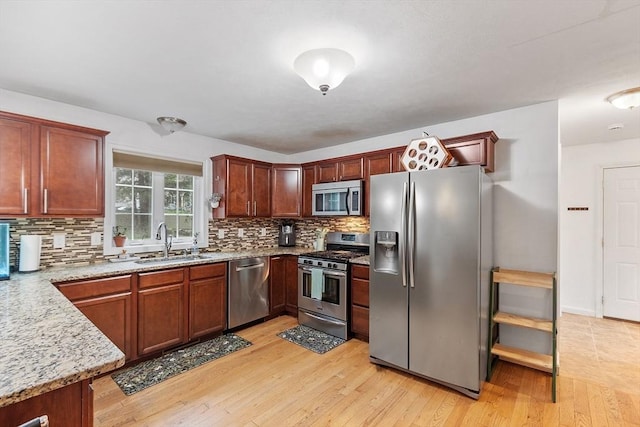38 Phyllis Ln, Greenfield, MA 01301 - kitchen featuring appliances with stainless steel finishes, a sink, backsplash, light wood finished floors, and light stone countertops