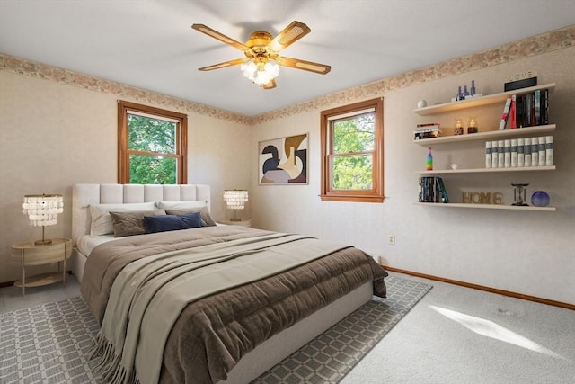 carpeted bedroom featuring multiple windows, baseboards, and a ceiling fan