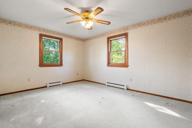 spare room featuring a baseboard heating unit, plenty of natural light, and carpet floors