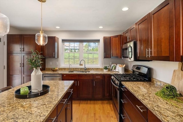4 Patriots Blvd Unit 4, Hopkinton, MA 01748 - kitchen featuring appliances with stainless steel finishes, a sink, light wood-type flooring, light stone countertops, and hanging light fixtures