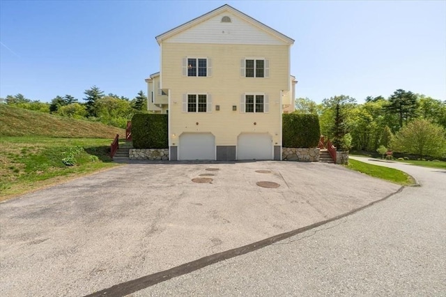 4 Patriots Blvd Unit 4, Hopkinton, MA 01748 - view of property exterior featuring driveway, a garage, and stairs