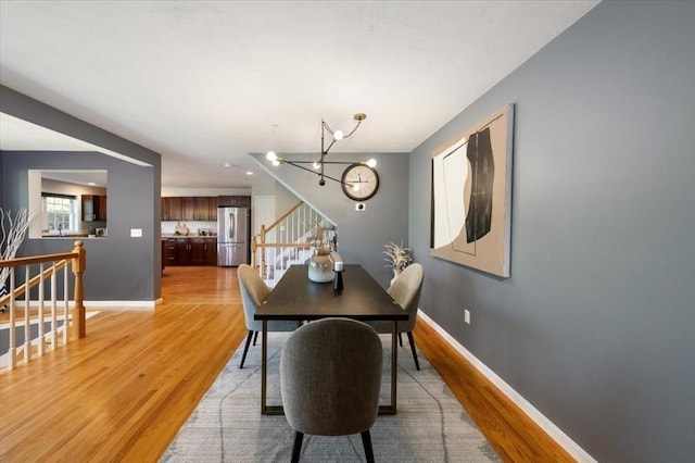 4 Patriots Blvd Unit 4, Hopkinton, MA 01748 - dining room featuring a chandelier, light wood-type flooring, stairs, and baseboards