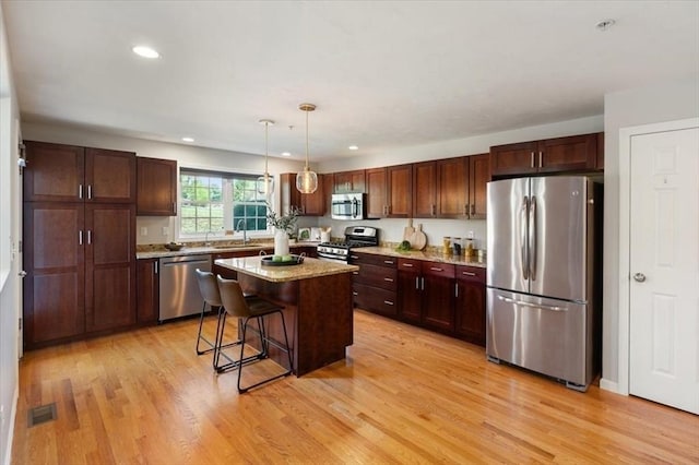 4 Patriots Blvd Unit 4, Hopkinton, MA 01748 - kitchen featuring stainless steel appliances, light wood finished floors, a kitchen island, hanging light fixtures, and recessed lighting