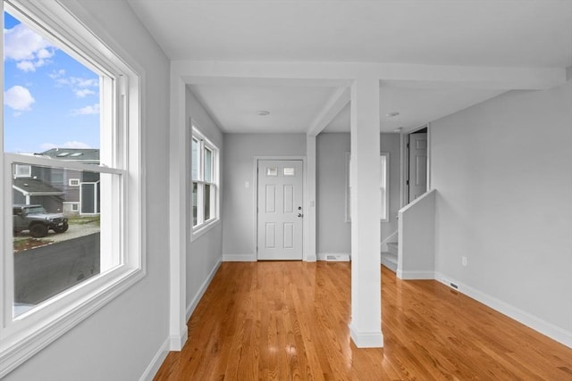 entrance foyer featuring light wood finished floors, baseboards, and healthy amount of natural light