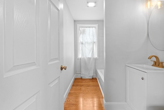 full bath featuring wood finished floors, baseboards, and vanity