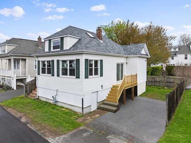 view of front of house with a chimney, stairway, and a shingled roof