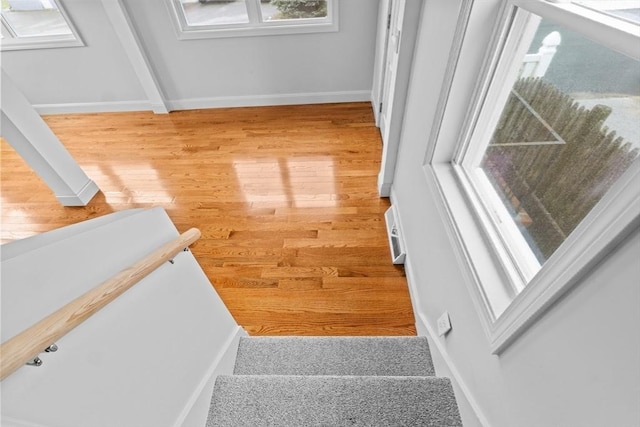 stairway with wood finished floors and baseboards