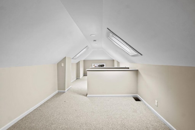 bonus room with vaulted ceiling, carpet flooring, baseboards, and a skylight