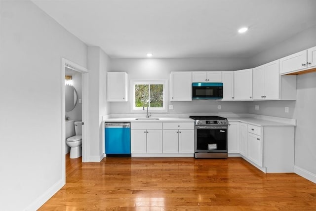 kitchen with dishwashing machine, gas stove, black microwave, a sink, and light countertops