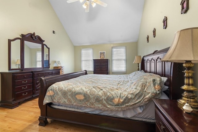 bedroom with a ceiling fan, visible vents, light wood finished floors, and lofted ceiling