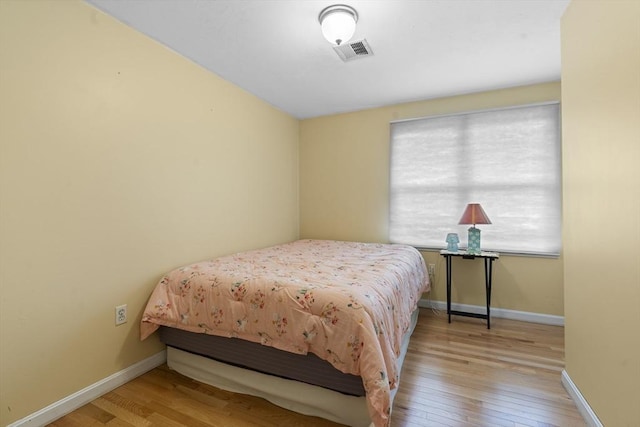 bedroom featuring visible vents, baseboards, and hardwood / wood-style flooring
