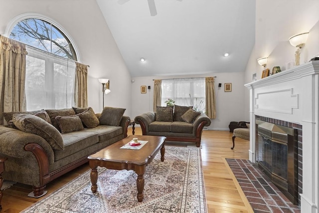 living room featuring ceiling fan, a fireplace, wood finished floors, high vaulted ceiling, and recessed lighting