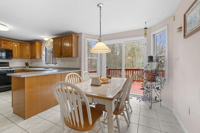 kitchen with range with gas stovetop, decorative backsplash, light tile patterned floors, and black microwave