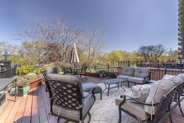 wooden terrace with outdoor dining area, outdoor lounge area, and fence