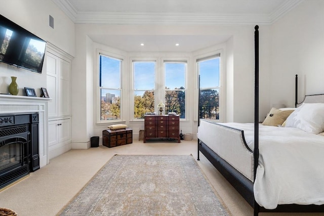 carpeted bedroom with multiple windows, visible vents, ornamental molding, and a glass covered fireplace