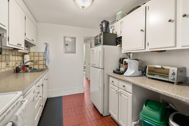 kitchen with freestanding refrigerator, white cabinets, a toaster, and tasteful backsplash
