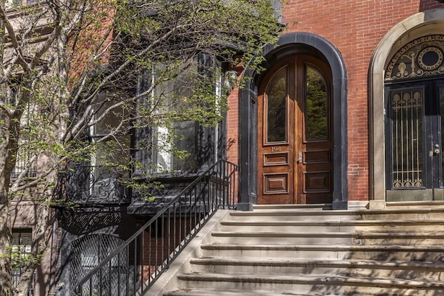 entrance to property featuring french doors and brick siding