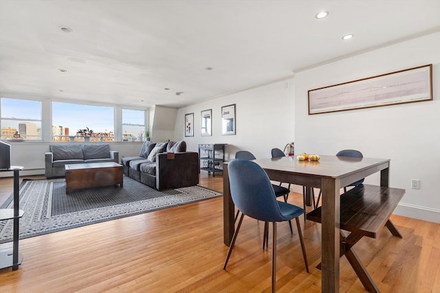 dining room with a baseboard heating unit, baseboards, light wood-type flooring, and recessed lighting