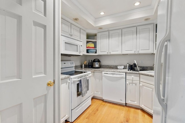 kitchen with white appliances, ornamental molding, recessed lighting, white cabinets, and a raised ceiling
