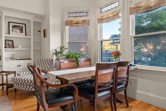 dining room featuring light wood finished floors and built in features
