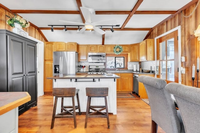 kitchen featuring a breakfast bar, sink, a kitchen island, stainless steel appliances, and backsplash