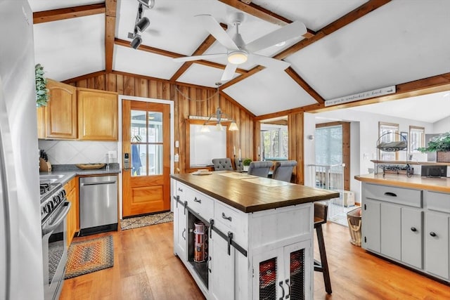 kitchen featuring pendant lighting, lofted ceiling with beams, and stainless steel appliances