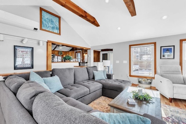 living room featuring hardwood / wood-style flooring, beam ceiling, and high vaulted ceiling