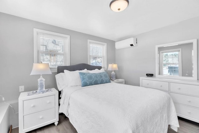 bedroom with wood-type flooring and a wall unit AC