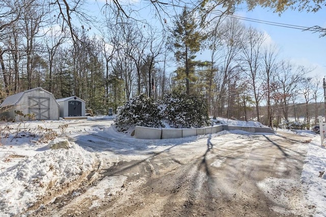 snowy yard with a storage shed