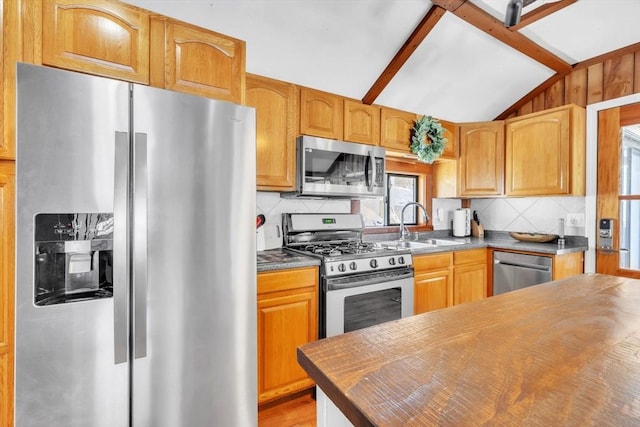 kitchen with stainless steel appliances, tasteful backsplash, lofted ceiling, and sink