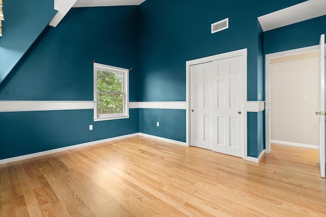 9 Twig Rush Ln, West Newbury, MA 01985 - unfurnished bedroom featuring wood finished floors, a closet, and high vaulted ceiling